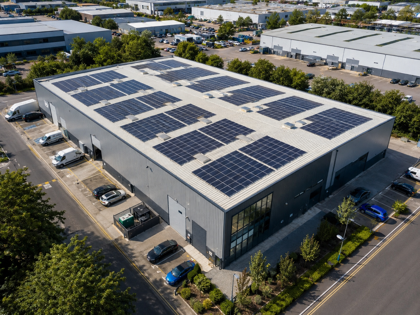 Aerial view of a UK industrial warehouse rooftop covered with commercial solar panels